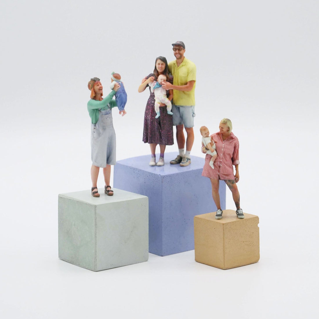 Figurines of a family with children on colorful blocks against a white background