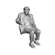 A seated man wearing flatcap