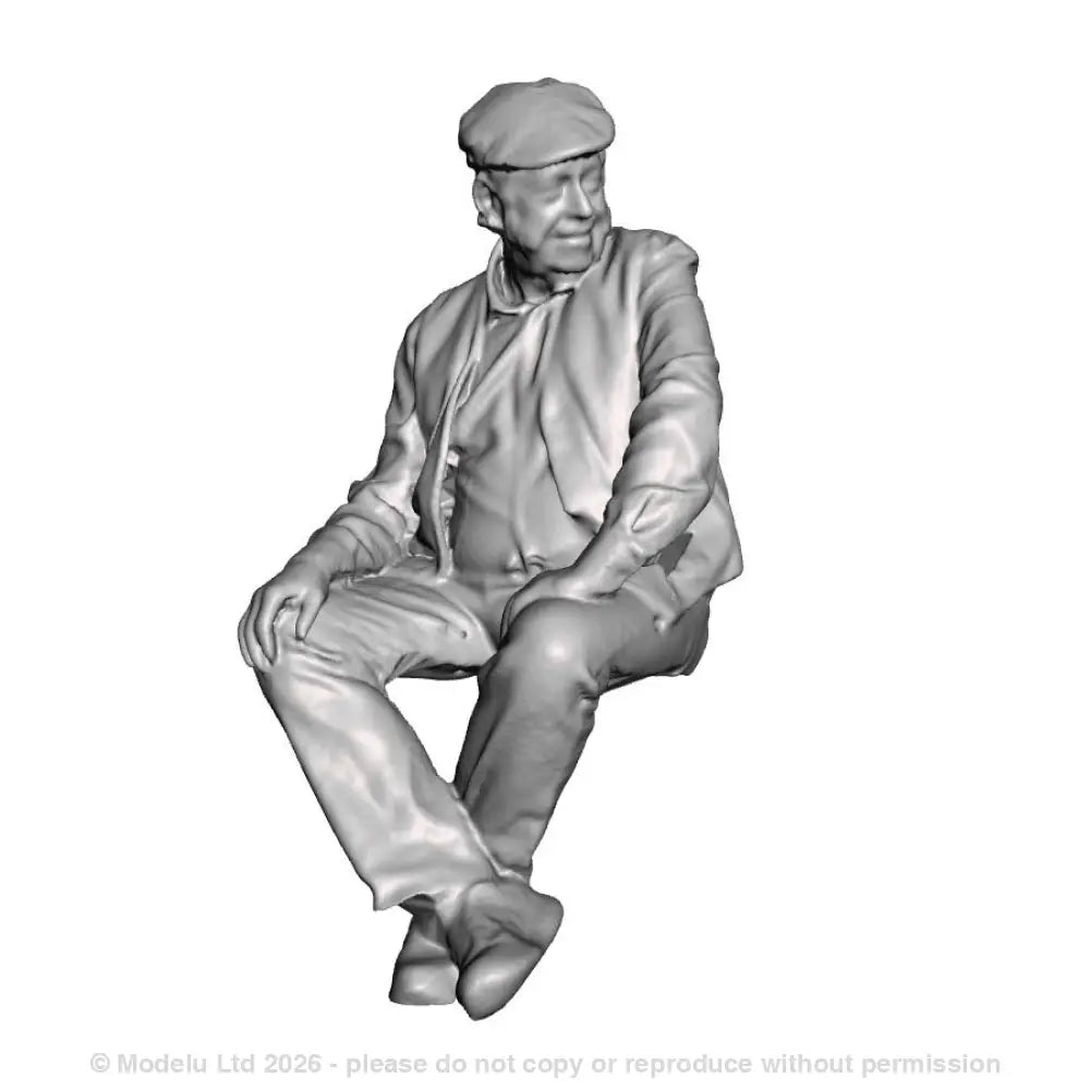 A seated man wearing flatcap