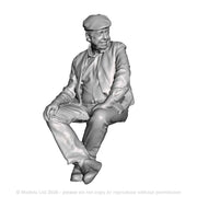 A seated man wearing flatcap