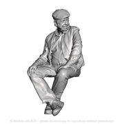 A seated man wearing flatcap