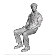 A seated man wearing flatcap