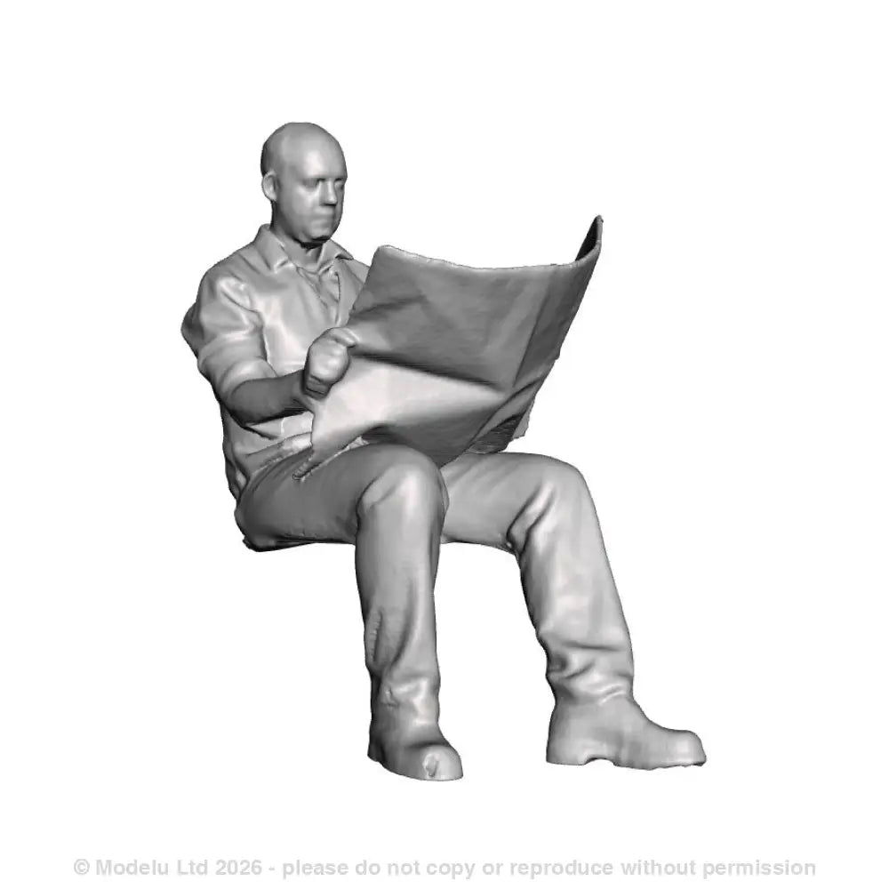 A seated man reading newspaper