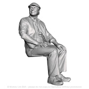 A seated man wearing flatcap