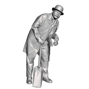 A fireman leaning wearing a bowler hat holding a firing shovel