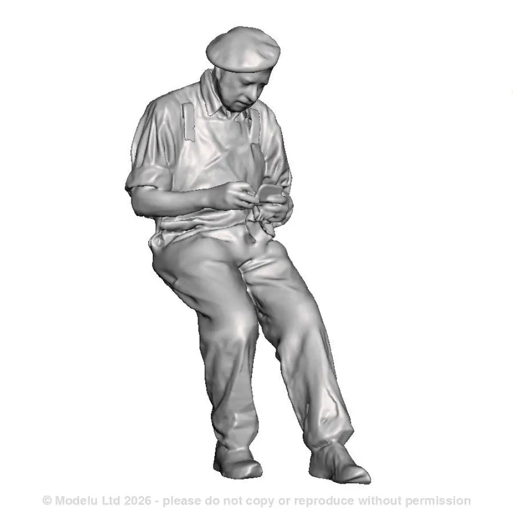 A loco crew man seated rolling a cigarette