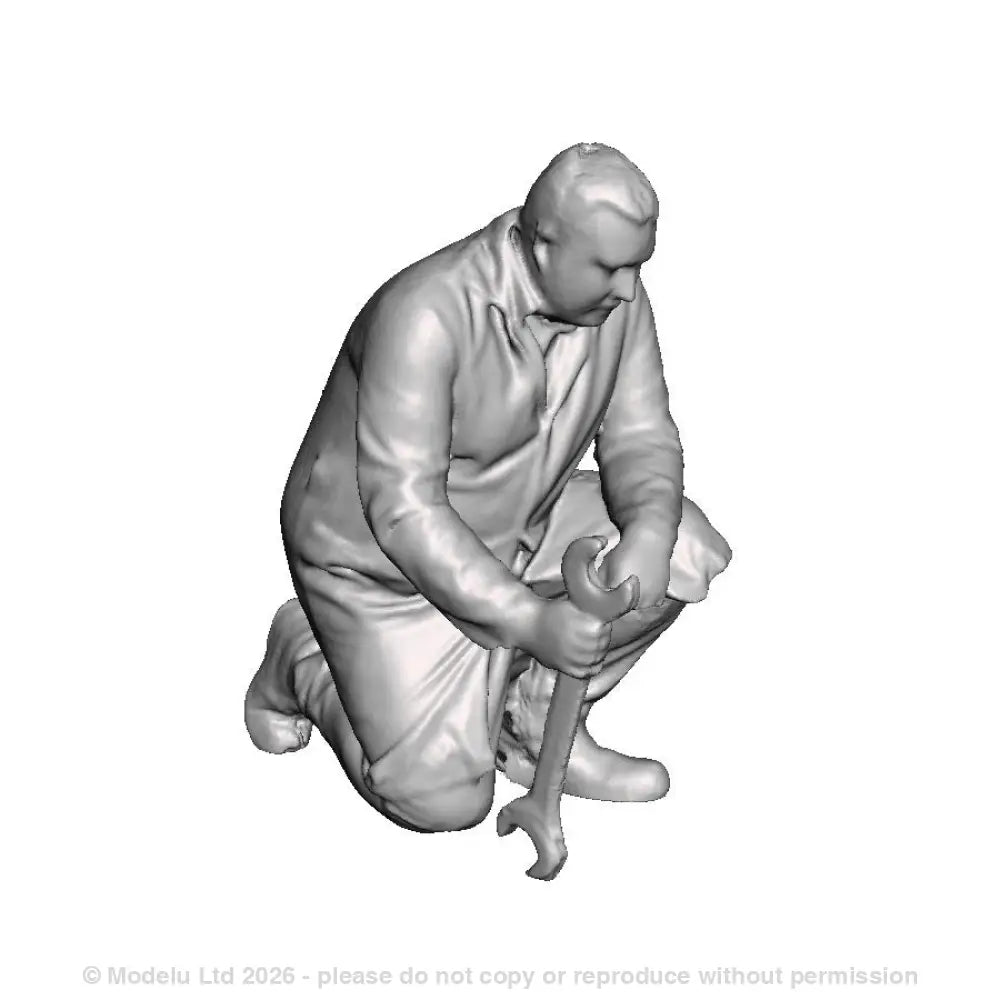 A fitter kneeling with spanner