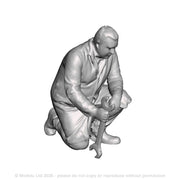 A fitter kneeling with spanner