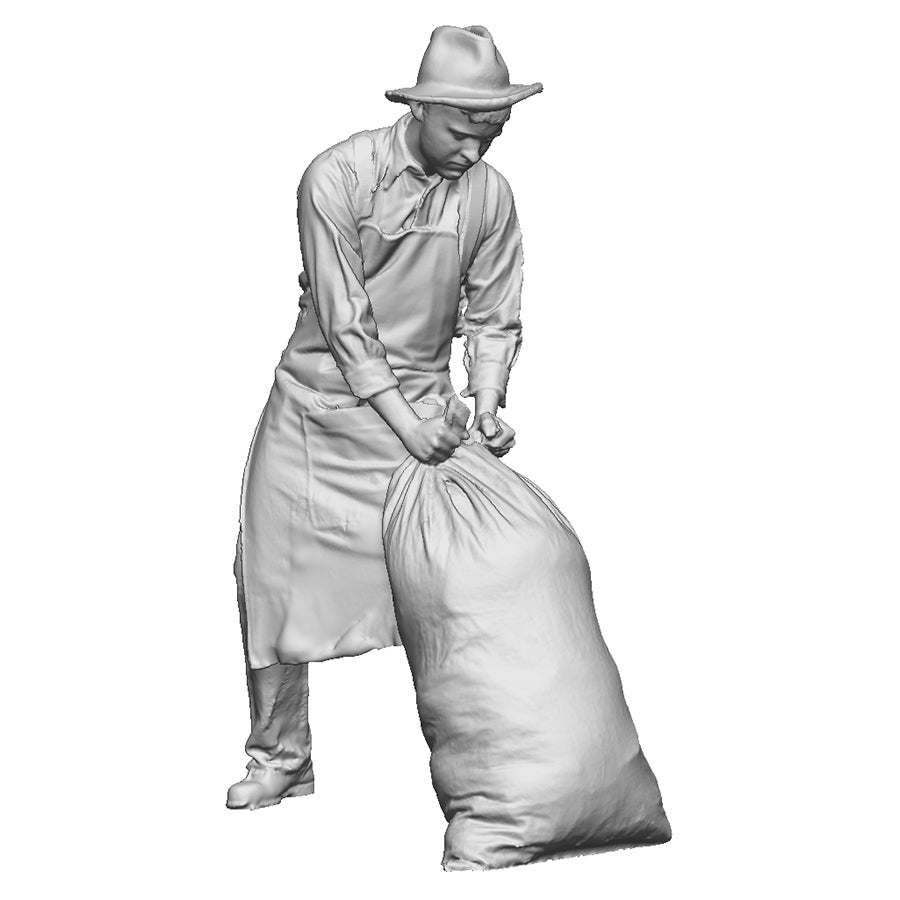 A mill worker moving sack