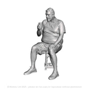 A male figure seated drinking