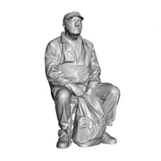 A male figure seated with rucksack